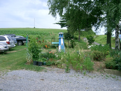 Picture of a blue and white model lighthouse in a garden